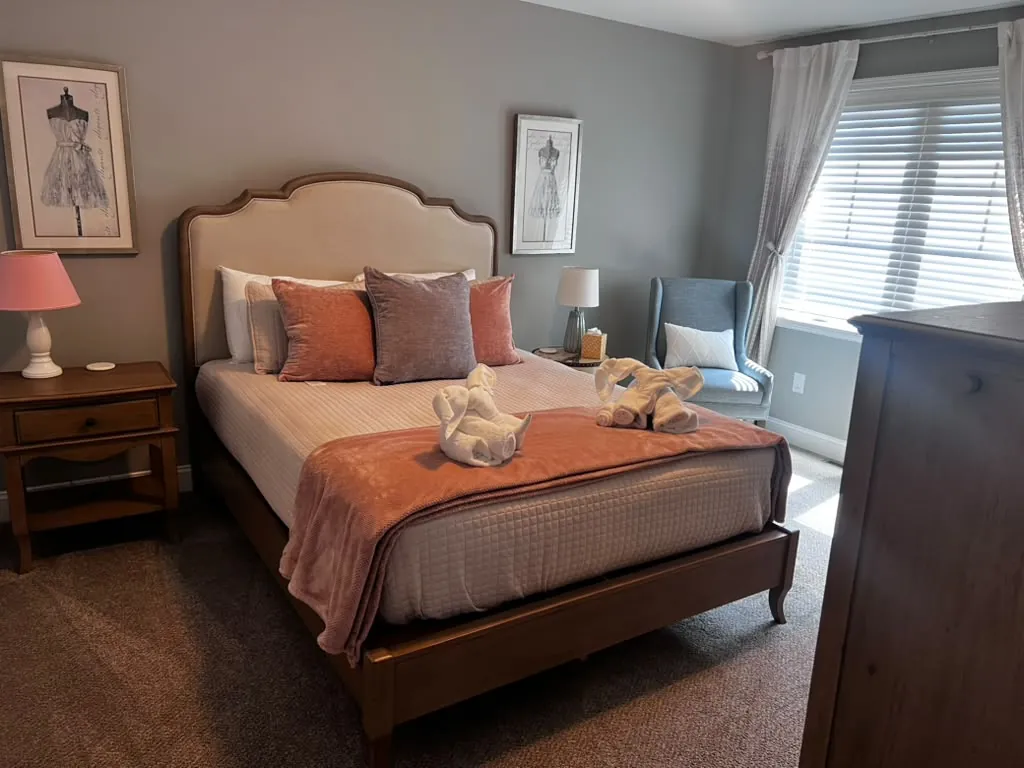 Guest bedroom made up with folded towel animals after Airbnb turnover cleaning