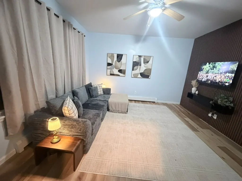 Living room with wood slat accent wall and TV cleaned after a renovation